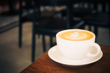 Restoran ve kafeterya masada beyaz fincan sıcak latte kahve