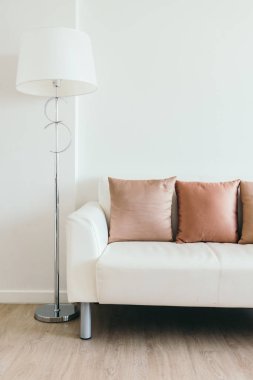 Işık lamba ile beyaz kanepede rahat yastık