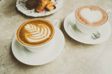 Beyaz fincan sütlü kahve ve kek ile