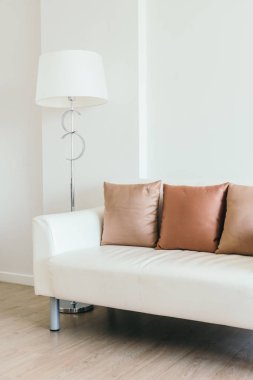 Işık lamba ile beyaz kanepede rahat yastık