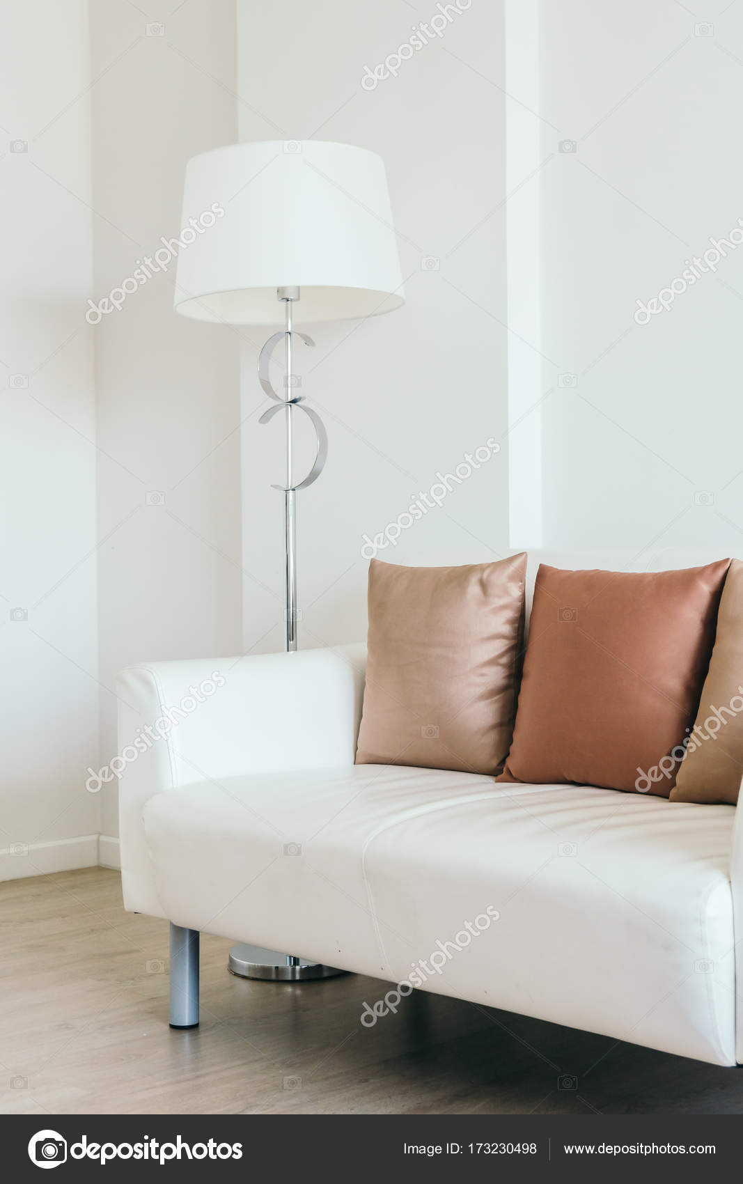 Comfortable Pillow On White Sofa With Light Lamp Stock Photo