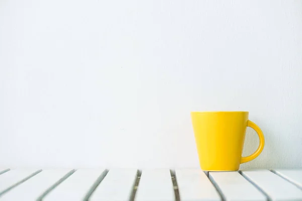 Yellow coffee cup on table — Stock Photo, Image