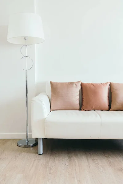 Travesseiro confortável no sofá branco com lâmpada de luz — Fotografia de Stock