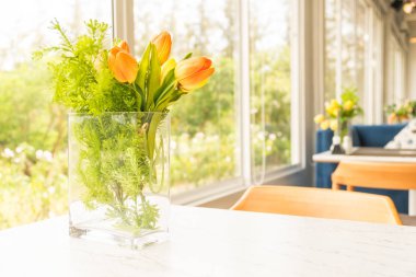 Cam vazo içinde sunulan plastik veya sahte çiçek