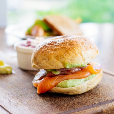Simit ekmek ile füme somon et ve sebze ahşap kesme tahtası üzerinde