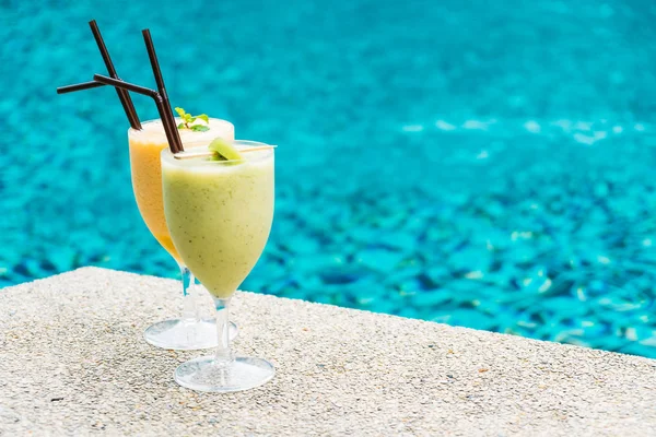 Iced fruit smoothies with pool background