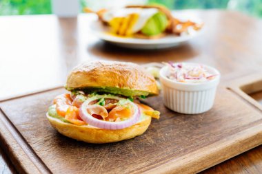 Simit ekmek ile füme somon et ve sebze ahşap kesme tahtası üzerinde