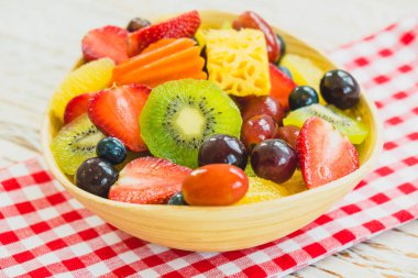 Kivi çilek üzüm ve diğer ahşap masa - filtre işleme üzerinde kase ile karışık ve çeşitli meyve