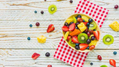 Kivi çilek üzüm ve diğer ahşap masa - filtre işleme üzerinde kase ile karışık ve çeşitli meyve