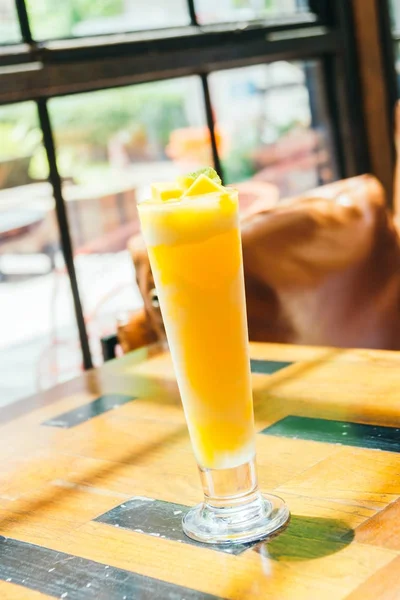 テーブルの上のマンゴーのスムージー ガラスを飲むアイス — ストック写真