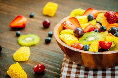 Kivi çilek üzüm ve diğer ahşap masa - filtre işleme üzerinde kase ile karışık ve çeşitli meyve