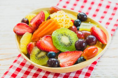 Kivi çilek üzüm ve diğer ahşap masa - filtre işleme üzerinde kase ile karışık ve çeşitli meyve