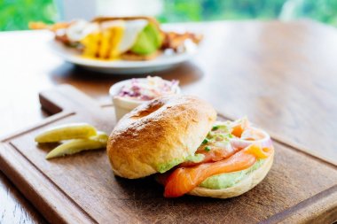 Simit ekmek ile füme somon et ve sebze ahşap kesme tahtası üzerinde