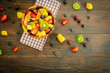 Kivi çilek üzüm ve diğer ahşap masa - filtre işleme üzerinde kase ile karışık ve çeşitli meyve