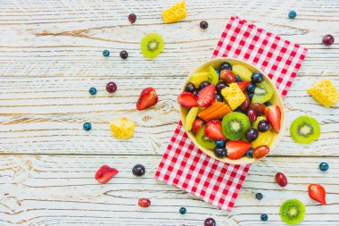 Kivi çilek üzüm ve diğer ahşap masa - filtre işleme üzerinde kase ile karışık ve çeşitli meyve