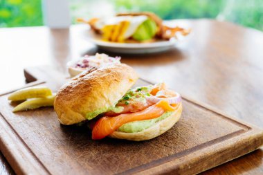 Simit ekmek ile füme somon et ve sebze ahşap kesme tahtası üzerinde