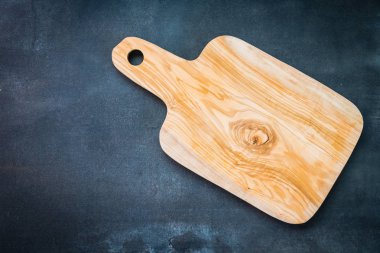 Siyah taş zemin üzerine ahşap kesme tahtası