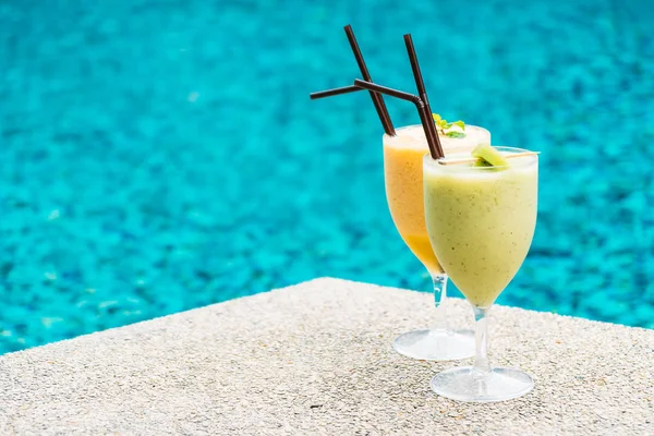 Iced fruit smoothies with pool background