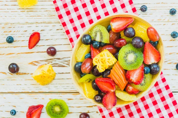 Mixed and assorted fruits with kiwi strawberry grape and other in bowl on wood table - Filter Processing