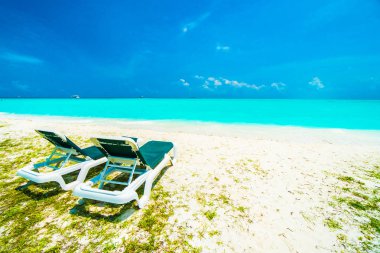 Güzel tropikal plaj ve Hindistan cevizi hurma ağacı ve mavi gökyüzü adam ile Maldivler adasında