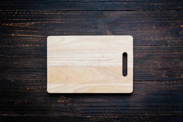 Wood cutting board on wooden background with copy space