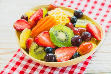 Kivi çilek üzüm ve diğer ahşap masa - filtre işleme üzerinde kase ile karışık ve çeşitli meyve