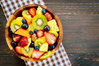 Kivi çilek üzüm ve diğer ahşap masa - filtre işleme üzerinde kase ile karışık ve çeşitli meyve