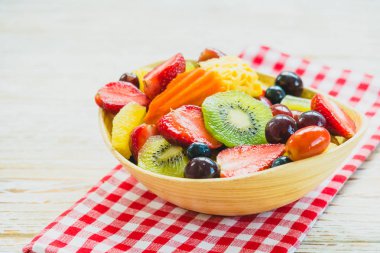 Kivi çilek üzüm ve diğer ahşap masa - filtre işleme üzerinde kase ile karışık ve çeşitli meyve