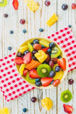 Kivi çilek üzüm ve diğer ahşap masa - filtre işleme üzerinde kase ile karışık ve çeşitli meyve