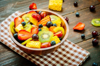 Kivi çilek üzüm ve diğer ahşap masa - filtre işleme üzerinde kase ile karışık ve çeşitli meyve