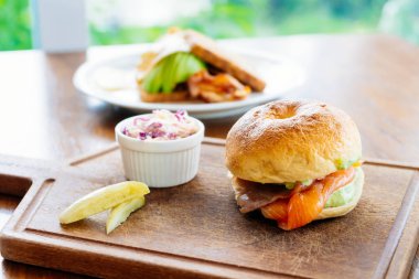 Simit ekmek ile füme somon et ve sebze ahşap kesme tahtası üzerinde