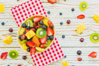 Kivi çilek üzüm ve diğer ahşap masa - filtre işleme üzerinde kase ile karışık ve çeşitli meyve