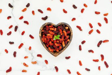 Kırmızı ve siyah dut meyve kase beyaz taş zemin üzerine