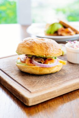 Simit ekmek ile füme somon et ve sebze ahşap kesme tahtası üzerinde