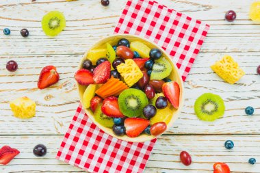 Kivi çilek üzüm ve diğer ahşap masa - filtre işleme üzerinde kase ile karışık ve çeşitli meyve