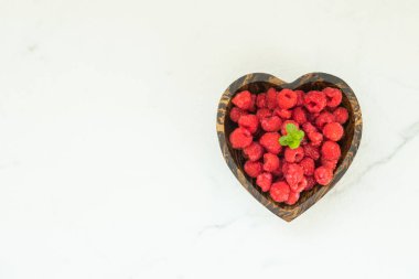 Kırmızı rasberries meyve masada ahşap kase