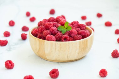 Kırmızı rasberries meyve masada ahşap kase