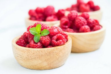 Kırmızı rasberries meyve masada ahşap kase