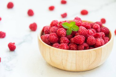 Kırmızı rasberries meyve masada ahşap kase