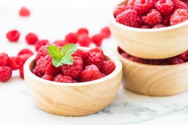 Kırmızı rasberries meyve masada ahşap kase