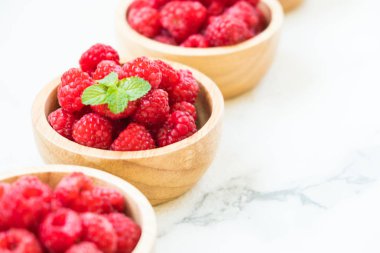 Kırmızı rasberries meyve masada ahşap kase