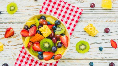 Kivi çilek üzüm ve diğer ahşap masa - filtre işleme üzerinde kase ile karışık ve çeşitli meyve