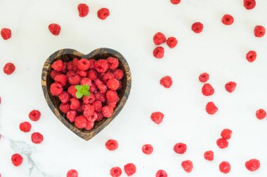 Kırmızı rasberries meyve masada ahşap kase