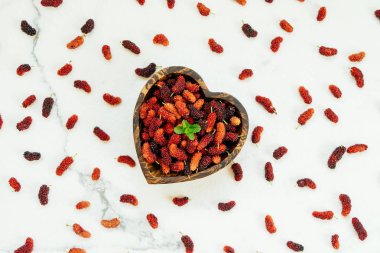 Kırmızı ve siyah dut meyve kase beyaz taş zemin üzerine