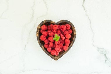Kırmızı rasberries meyve masada ahşap kase