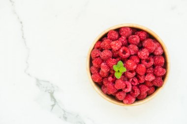 Kırmızı rasberries meyve masada ahşap kase