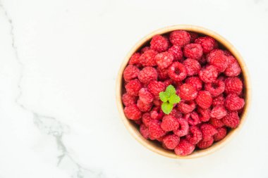 Kırmızı rasberries meyve masada ahşap kase