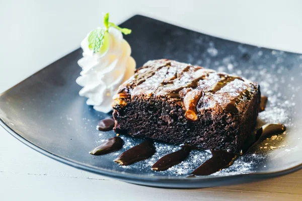 Chocolate brownies cake with whipped cream and cherry