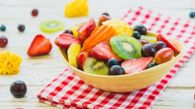 Kivi çilek üzüm ve diğer ahşap masa - filtre işleme üzerinde kase ile karışık ve çeşitli meyve