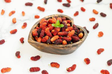 Kırmızı ve siyah dut meyve kase beyaz taş zemin üzerine